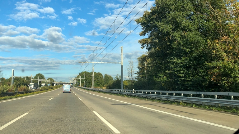 Autobahn mit LKW Stromtrasse