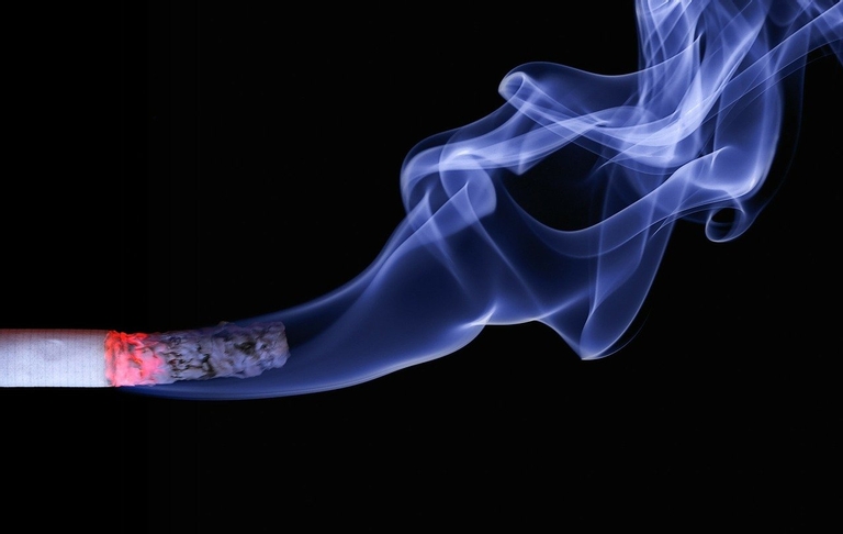 Eine Zigarette brennt und verursacht Rauch